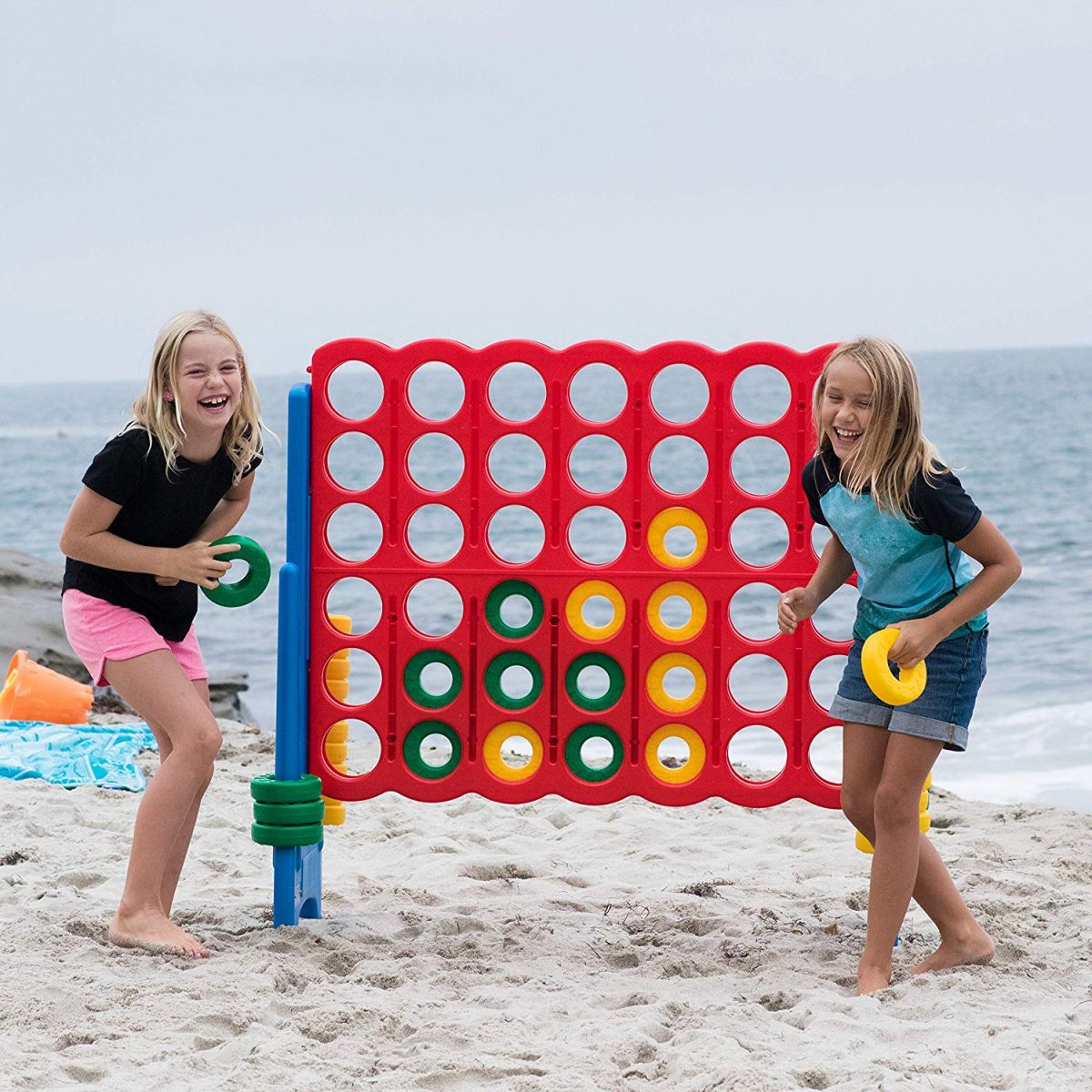 Girls playing giant connect 4 game at the beach